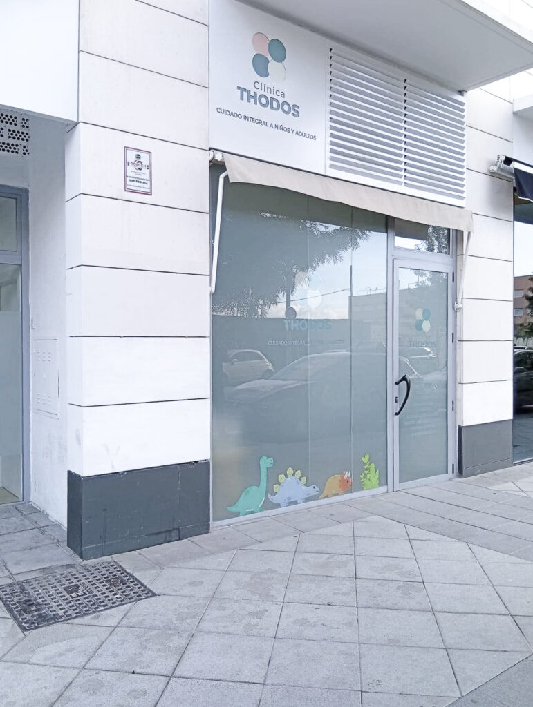 Fachada exterior de la Clínica Thodos Granada con el letrero del centro médico visible, mostrando la entrada principal de la clínica de pediatría y alergología